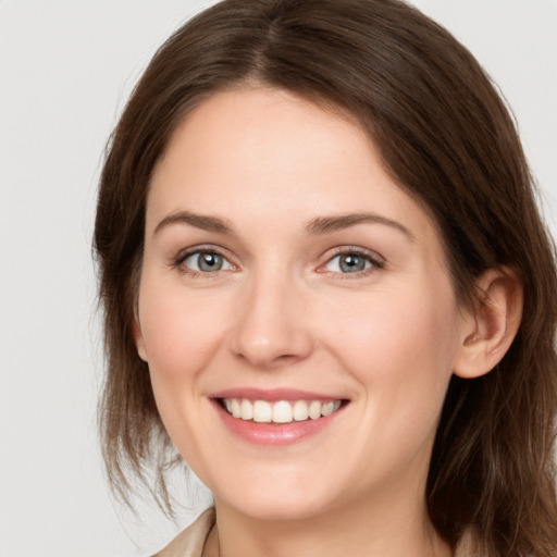 Joyful white young-adult female with medium  brown hair and grey eyes