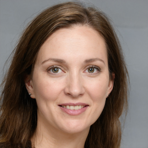 Joyful white adult female with long  brown hair and grey eyes