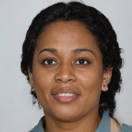 Joyful black adult female with medium  black hair and brown eyes