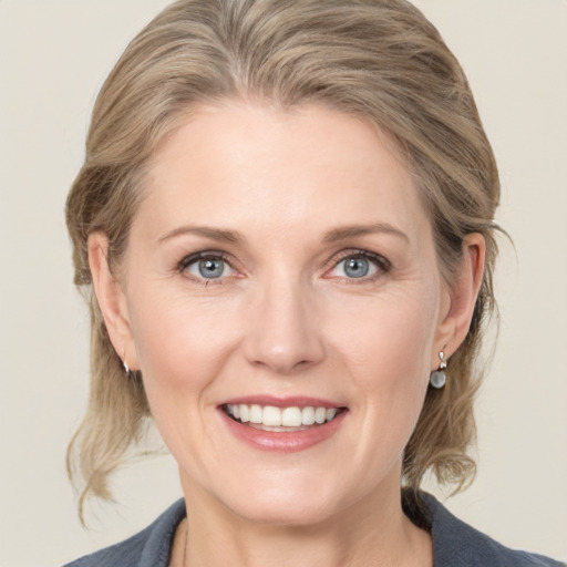 Joyful white adult female with medium  brown hair and grey eyes