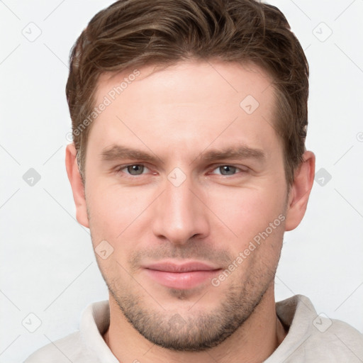 Joyful white young-adult male with short  brown hair and grey eyes