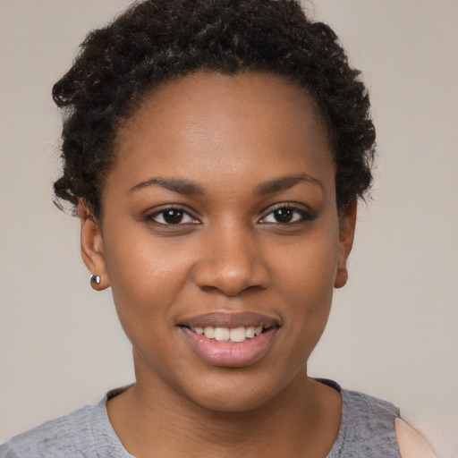 Joyful black young-adult female with short  brown hair and brown eyes