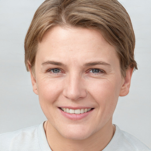 Joyful white young-adult female with short  brown hair and grey eyes