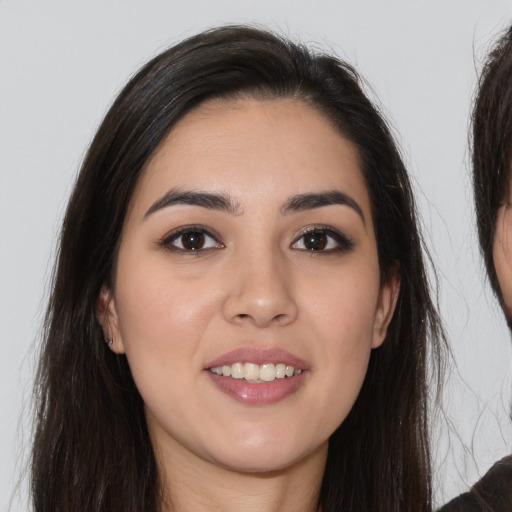 Joyful white young-adult female with long  brown hair and brown eyes