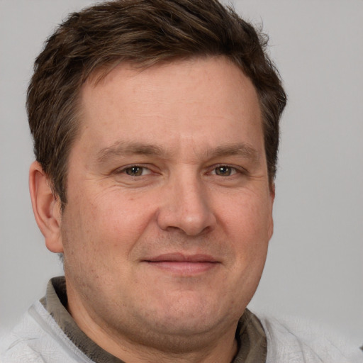 Joyful white adult male with short  brown hair and grey eyes