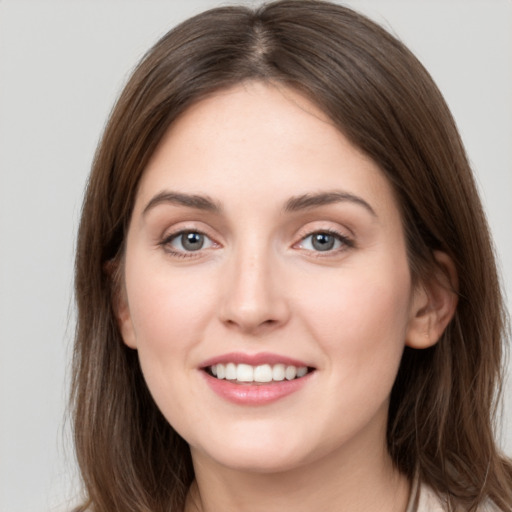 Joyful white young-adult female with long  brown hair and grey eyes