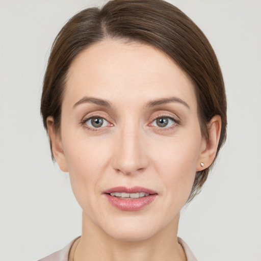 Joyful white young-adult female with medium  brown hair and grey eyes