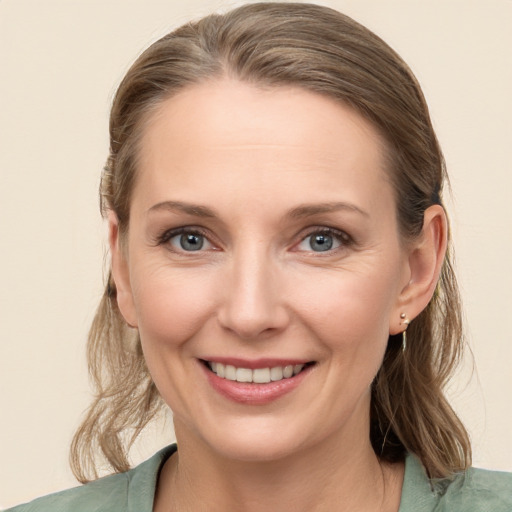 Joyful white young-adult female with medium  brown hair and blue eyes