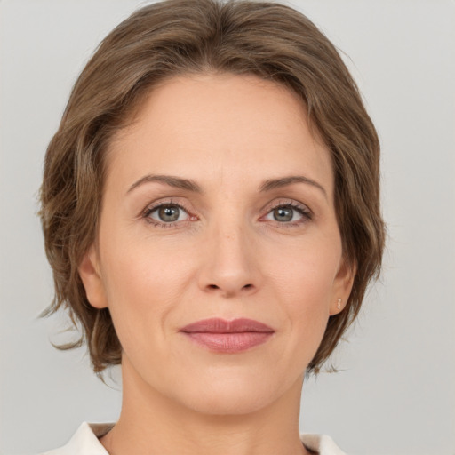 Joyful white adult female with medium  brown hair and grey eyes