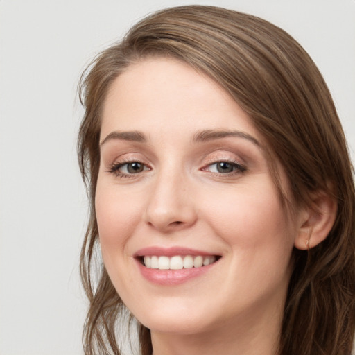 Joyful white young-adult female with long  brown hair and blue eyes