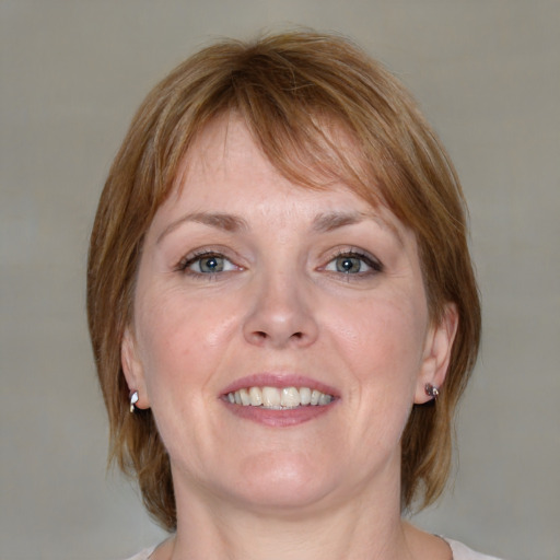 Joyful white adult female with medium  brown hair and blue eyes