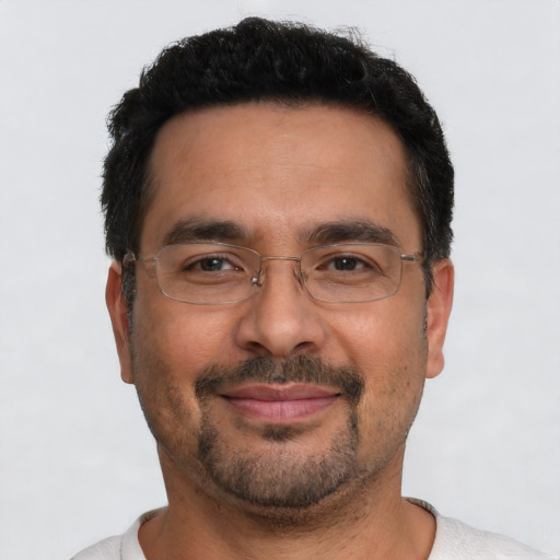 Joyful latino adult male with short  black hair and brown eyes