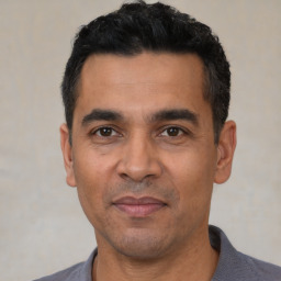Joyful latino adult male with short  black hair and brown eyes