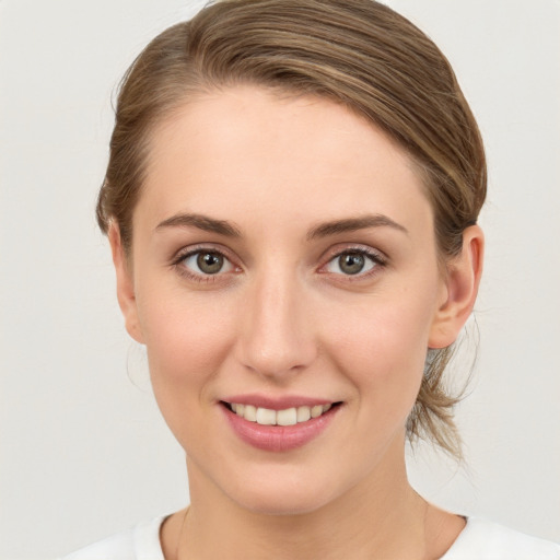 Joyful white young-adult female with medium  brown hair and grey eyes