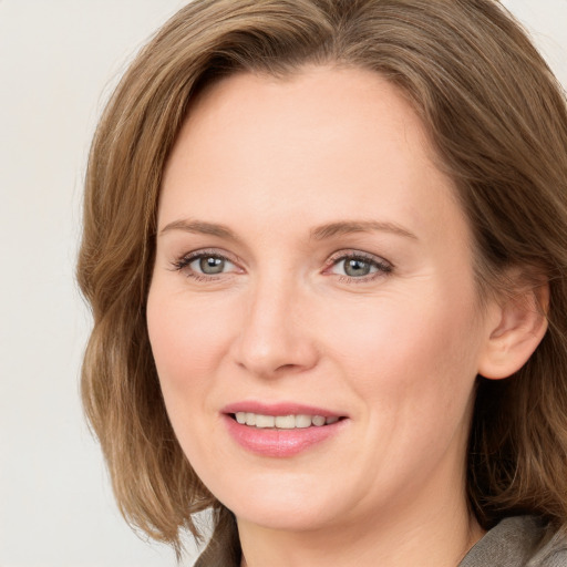 Joyful white young-adult female with long  brown hair and blue eyes