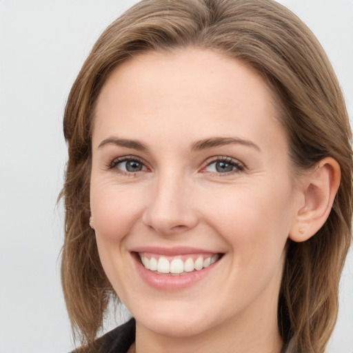 Joyful white young-adult female with long  brown hair and blue eyes