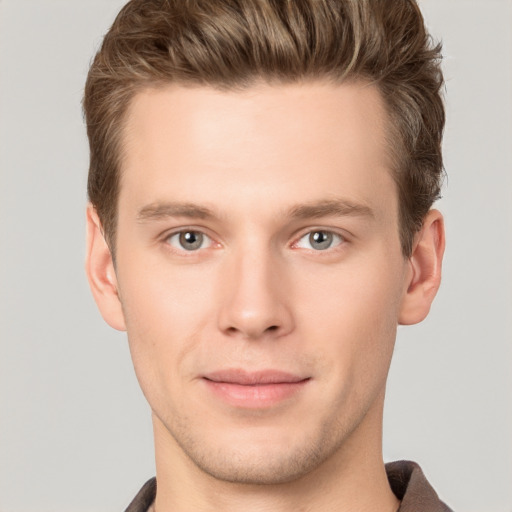 Joyful white young-adult male with short  brown hair and grey eyes