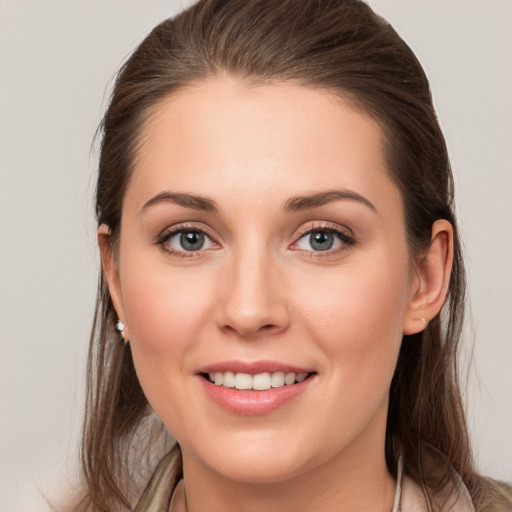 Joyful white young-adult female with long  brown hair and grey eyes