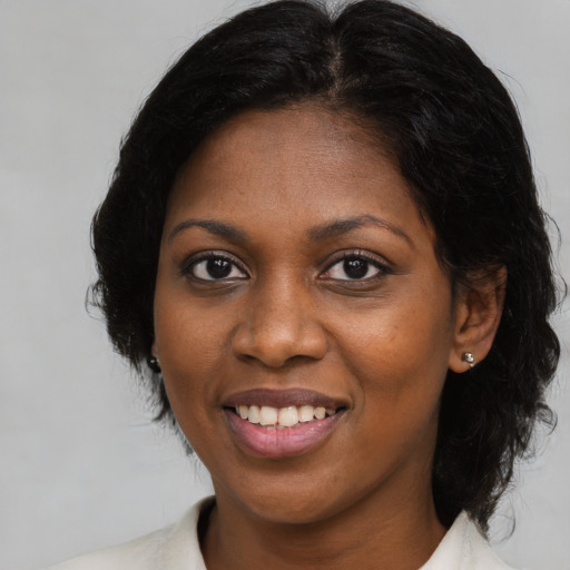 Joyful black adult female with medium  brown hair and brown eyes