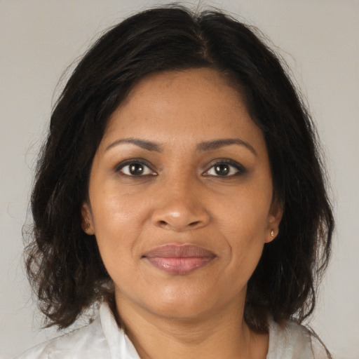 Joyful black adult female with medium  brown hair and brown eyes