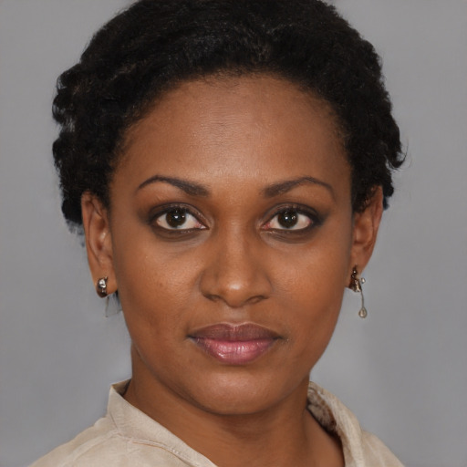 Joyful black young-adult female with short  brown hair and brown eyes