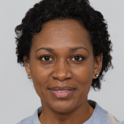 Joyful black adult female with short  brown hair and brown eyes