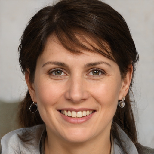 Joyful white adult female with medium  brown hair and grey eyes