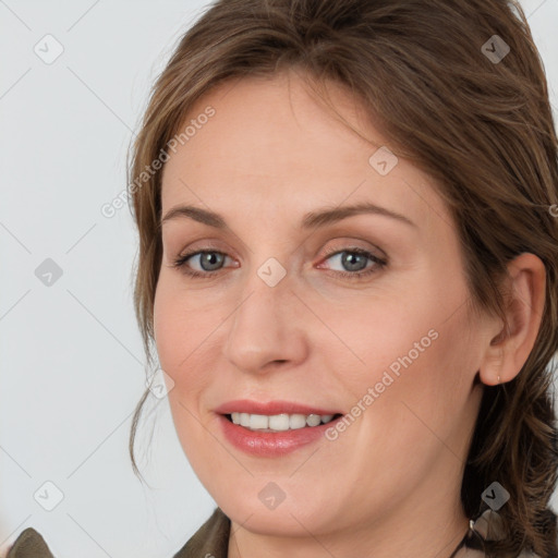 Joyful white young-adult female with medium  brown hair and grey eyes