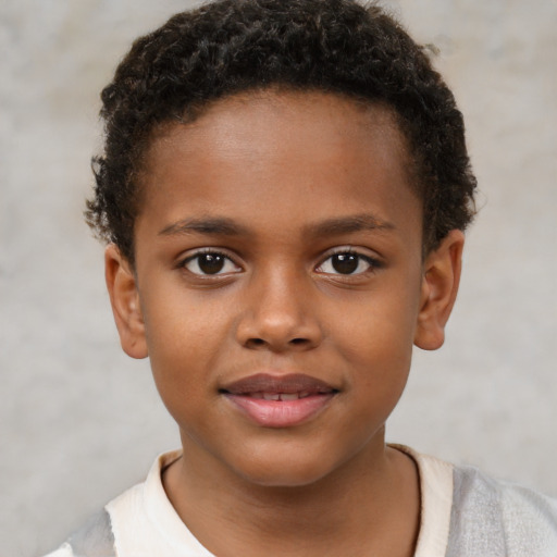 Joyful black child male with short  brown hair and brown eyes
