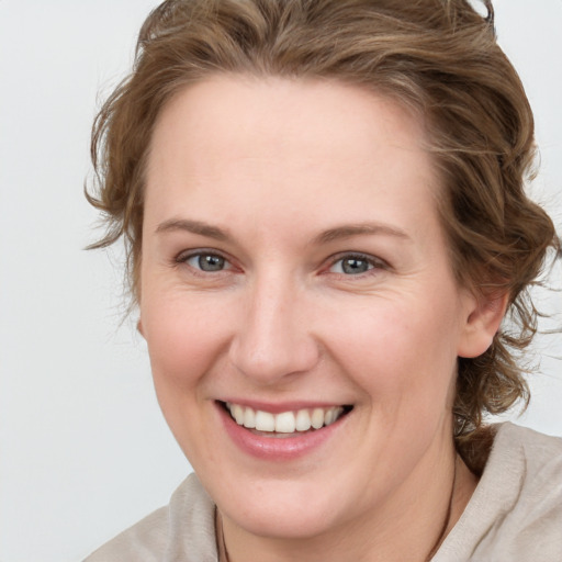 Joyful white young-adult female with medium  brown hair and blue eyes