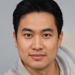 Joyful asian young-adult male with short  brown hair and brown eyes