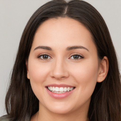 Joyful white young-adult female with long  brown hair and brown eyes