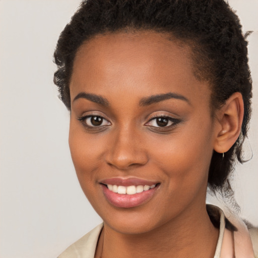 Joyful black young-adult female with long  brown hair and brown eyes