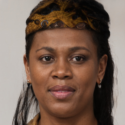 Joyful black young-adult female with long  brown hair and brown eyes