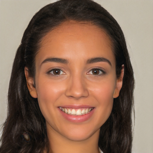 Joyful latino young-adult female with long  brown hair and brown eyes