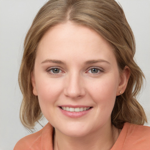 Joyful white young-adult female with medium  brown hair and blue eyes