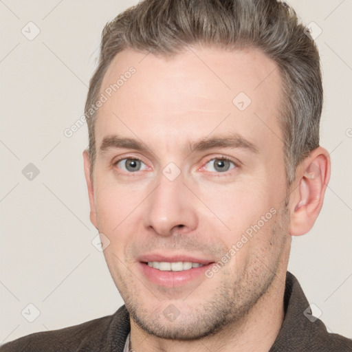 Joyful white adult male with short  brown hair and brown eyes