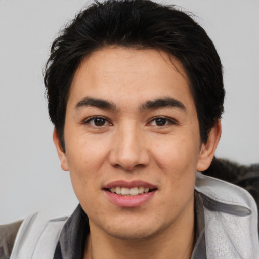 Joyful latino young-adult male with short  brown hair and brown eyes