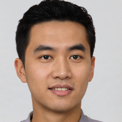 Joyful asian young-adult male with short  black hair and brown eyes