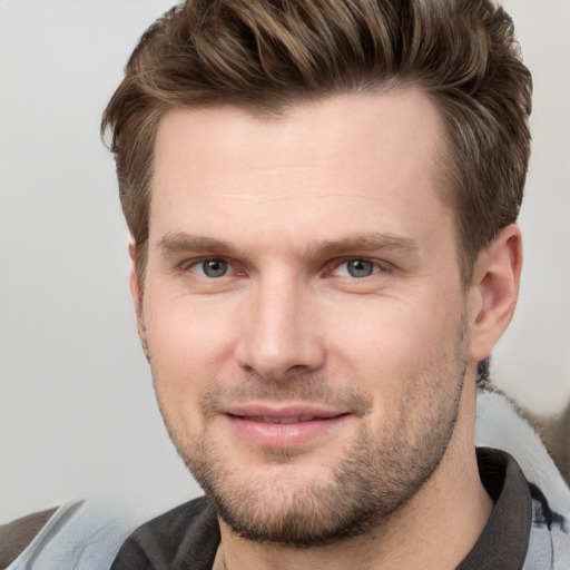 Joyful white young-adult male with short  brown hair and grey eyes