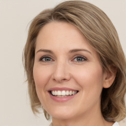 Joyful white young-adult female with medium  brown hair and green eyes