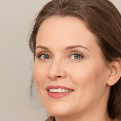 Joyful white adult female with medium  brown hair and brown eyes