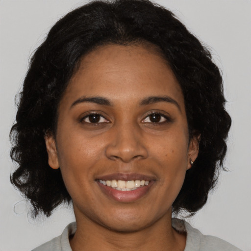 Joyful black young-adult female with medium  brown hair and brown eyes
