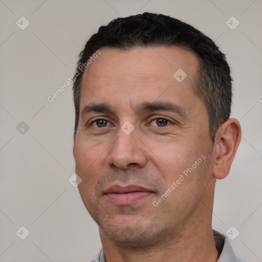 Joyful white adult male with short  black hair and brown eyes