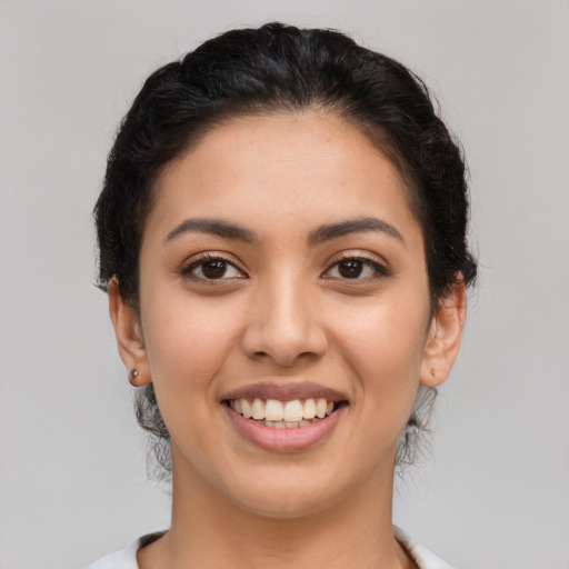 Joyful latino young-adult female with short  brown hair and brown eyes
