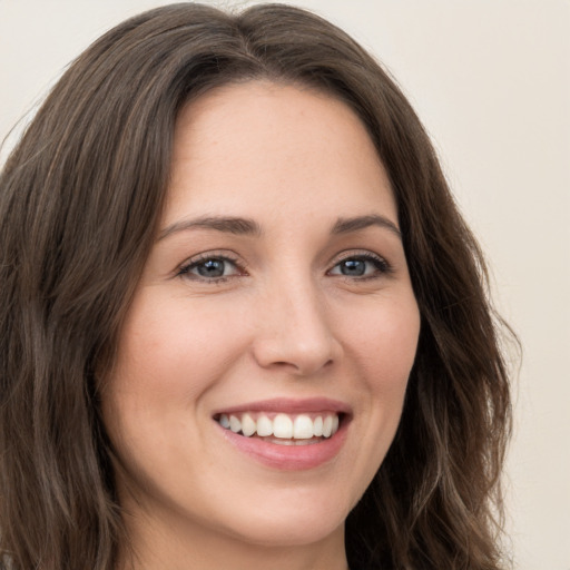 Joyful white young-adult female with long  brown hair and green eyes