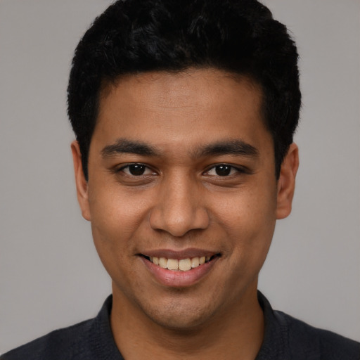 Joyful latino young-adult male with short  black hair and brown eyes