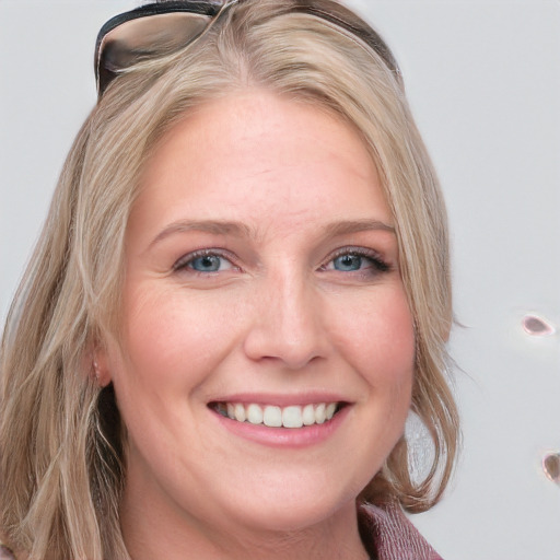 Joyful white young-adult female with long  blond hair and blue eyes