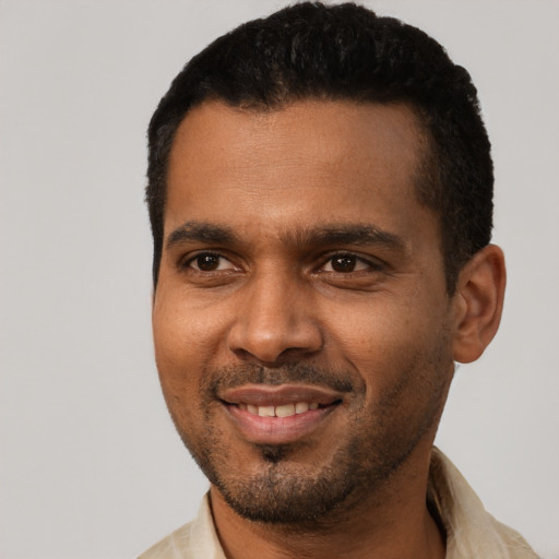 Joyful black young-adult male with short  black hair and brown eyes