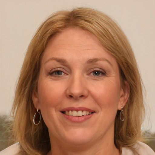 Joyful white adult female with medium  brown hair and blue eyes